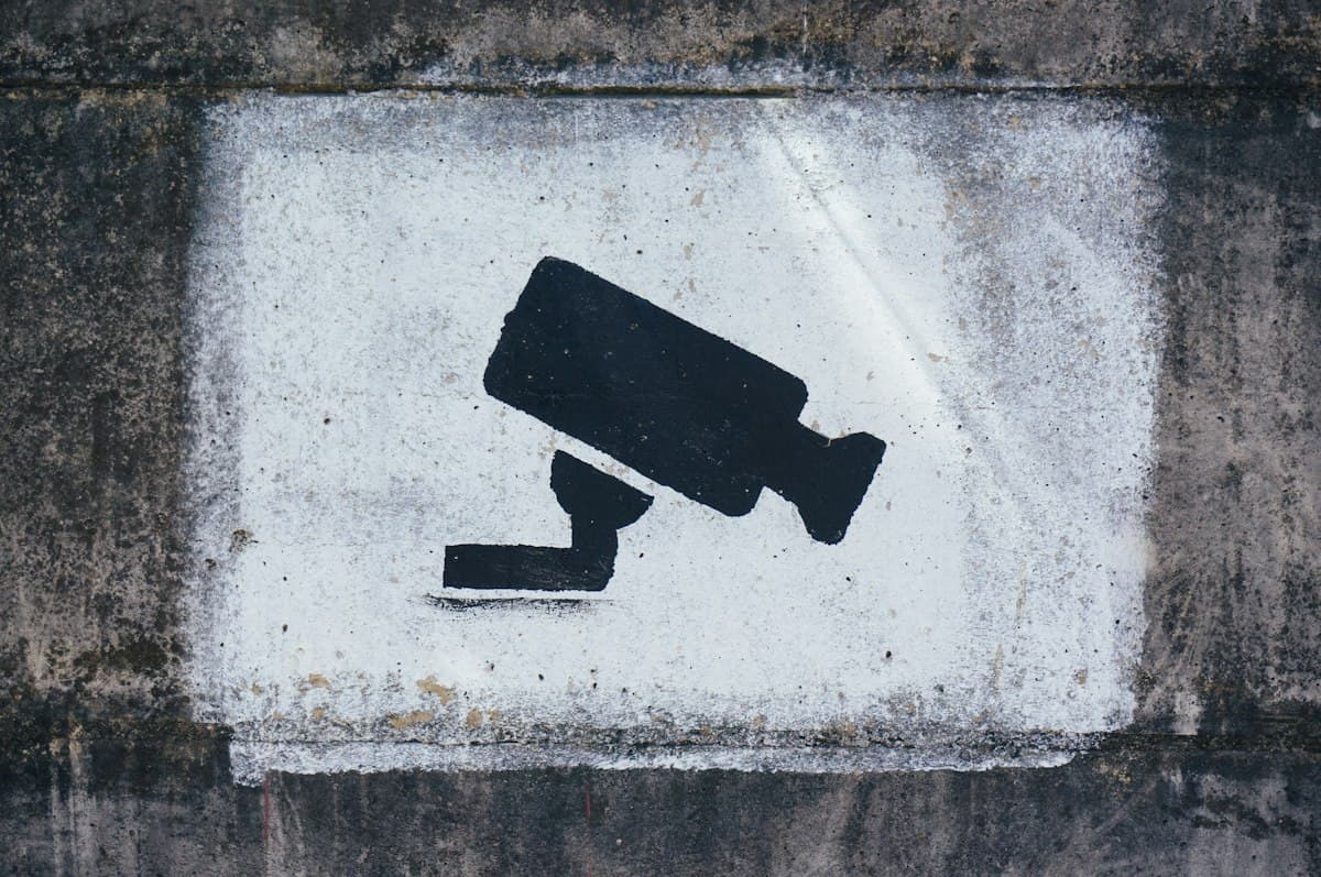 Painted security camera symbol on a wall